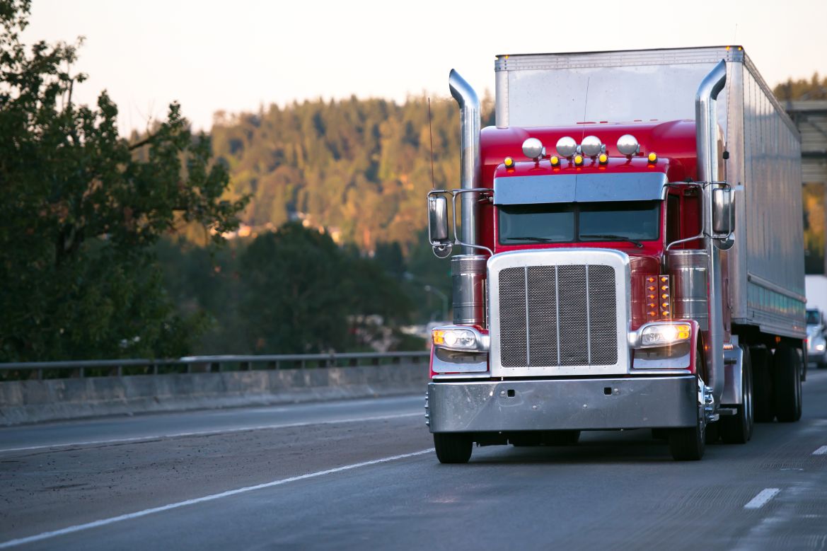 A lovely red truck driving down the road