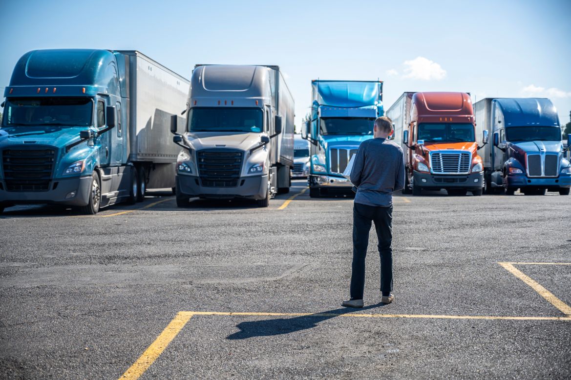 Man inspecting a truck line while holding documents