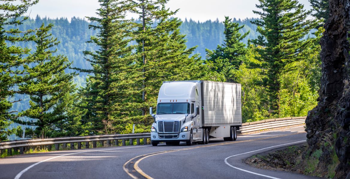 a semi truck driving down a winding road