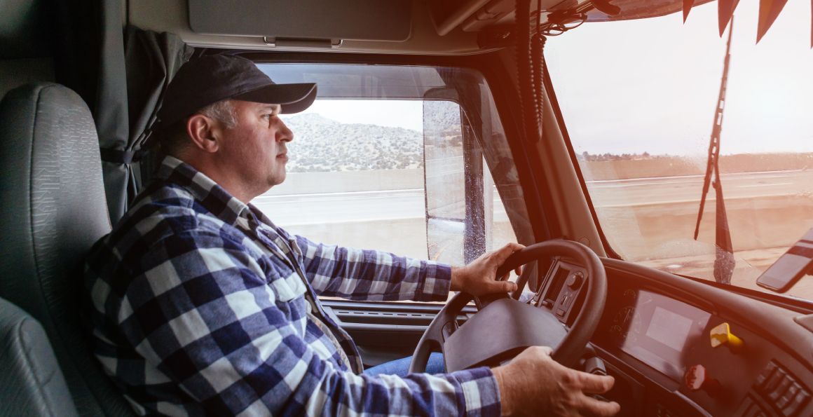 Driver in cabin of big modern truck