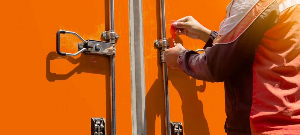 Courier driver using door lock seal. Container door truck lock with protective lead seal. Security of cargo shipment.
